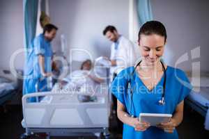 Smiling female doctor using digital tablet in ward