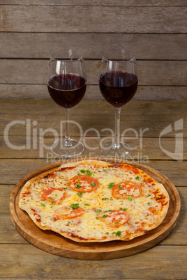 Delicious pizza with glasses of red wine