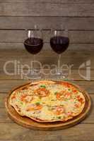 Delicious pizza with glasses of red wine
