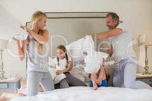 Cute family having a pillow fight in bedroom