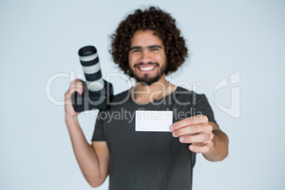 Male photographer showing visiting card in studio