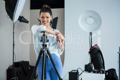 Happy female photographer standing in studio