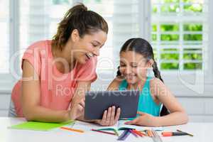 Mother and daughter using digital tablet