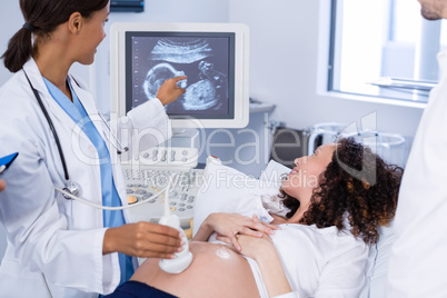 Doctor doing ultrasound scan for pregnant woman