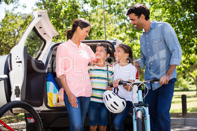 Happy family on a picnic standing next to their car