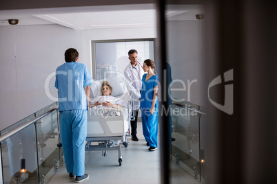 Team of doctors interacting with each other while examining pregnant woman