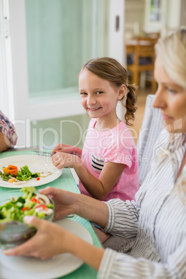 Cute girl having meal on dinning table