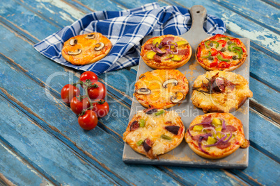 Various delicious italian pizza served on pizza tray with tomatoes