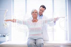 Physiotherapist giving hand massage to senior woman