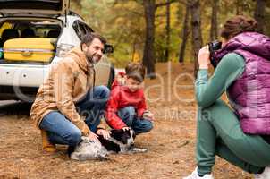 Happy family playing with dog in forest