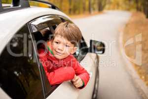 Smiling boy looking through car window