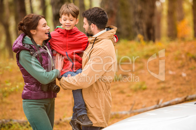 Happy family near car in forest