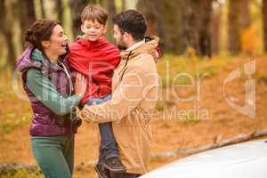 Happy family near car in forest