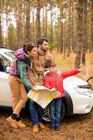 Family with map near car in forest