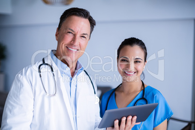 Portrait of smiling doctors using digital tablet