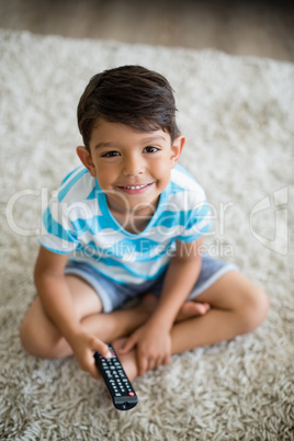 Portrait of smiling boy watching television in living room