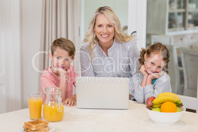 Mother and kids with laptop in kitchen