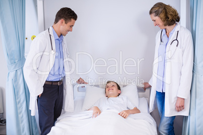 Two doctors talking to a boy patient
