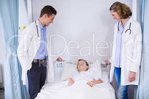 Two doctors talking to a boy patient