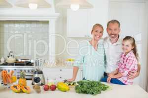 Portrait of parents with her daughter in kitchen