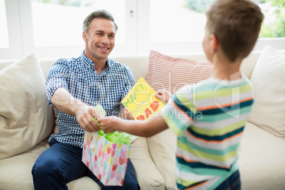 Father receiving a gift from his son in living room