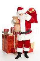 Santa Claus with pile of Christmas gifts