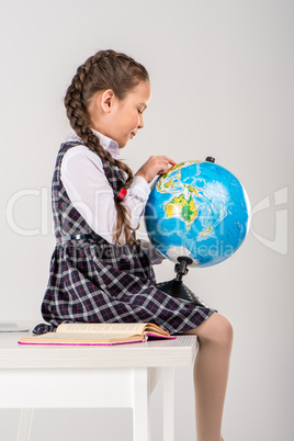 Schoolgirl exploring world on globe