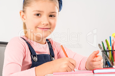 Smiling schoolgirl doing homework