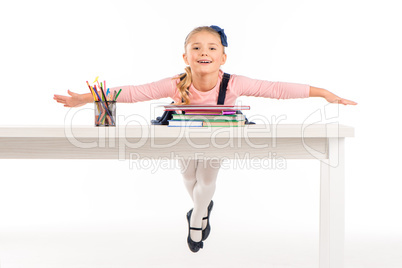 Cheerful schoolgirl lying on desk