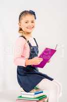 Smiling schoolgirl holding book
