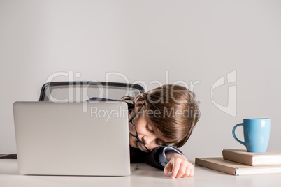 schoolchild in business suit sleeping on desk