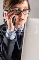 Schoolchild in business suit talking on smartphone