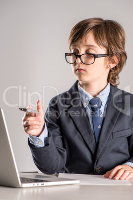 Schoolchild in business suit with pen in hands