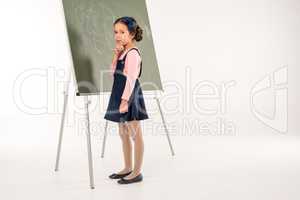 Schoolgirl standing near chalkboard