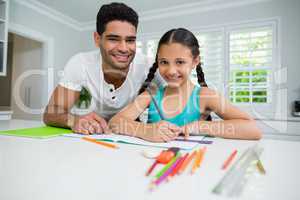 Father assisting her daughter in doing her homework at home