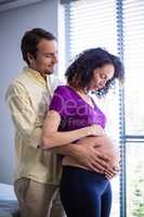Man touching pregnant womans belly in ward