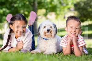 Portrait of siblings having fun with their pet dog
