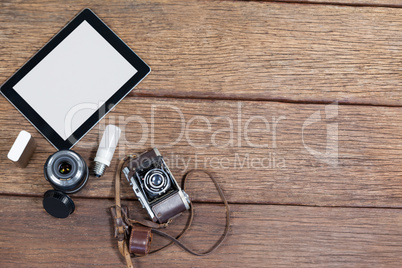 Close-up of old fashioned camera, lens, bulb, digital tablet on table