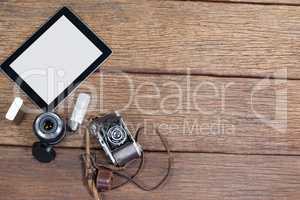 Close-up of old fashioned camera, lens, bulb, digital tablet on table