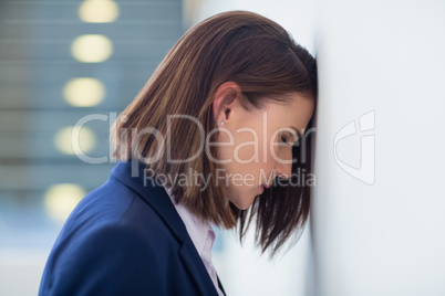 Worried businesswoman leaning her head on wall