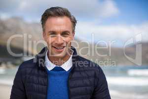 Smiling mature man standing on the beach