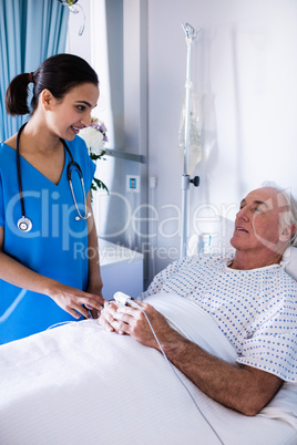 Female doctor interacting with male senior patient