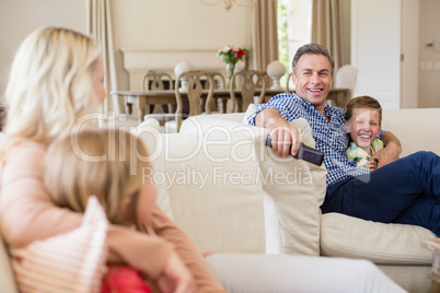 Family interacting with each other while watching tv in living room