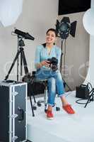Happy female photographer in studio