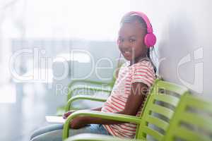 Portrait of girl listening to music from digital tablet