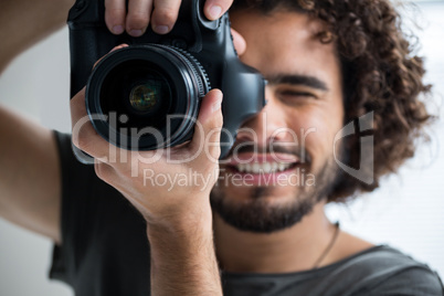 Male photographer with digital camera in studio