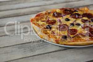 Italian pizza in a plate on a wooden plank