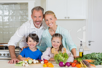 Portrait of parents and their two kids standing in kitchen