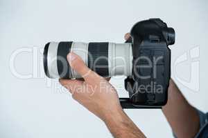 Close-up of photographer holding digital camera