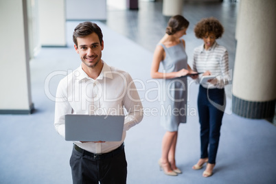Cheerful businessman holding laptop